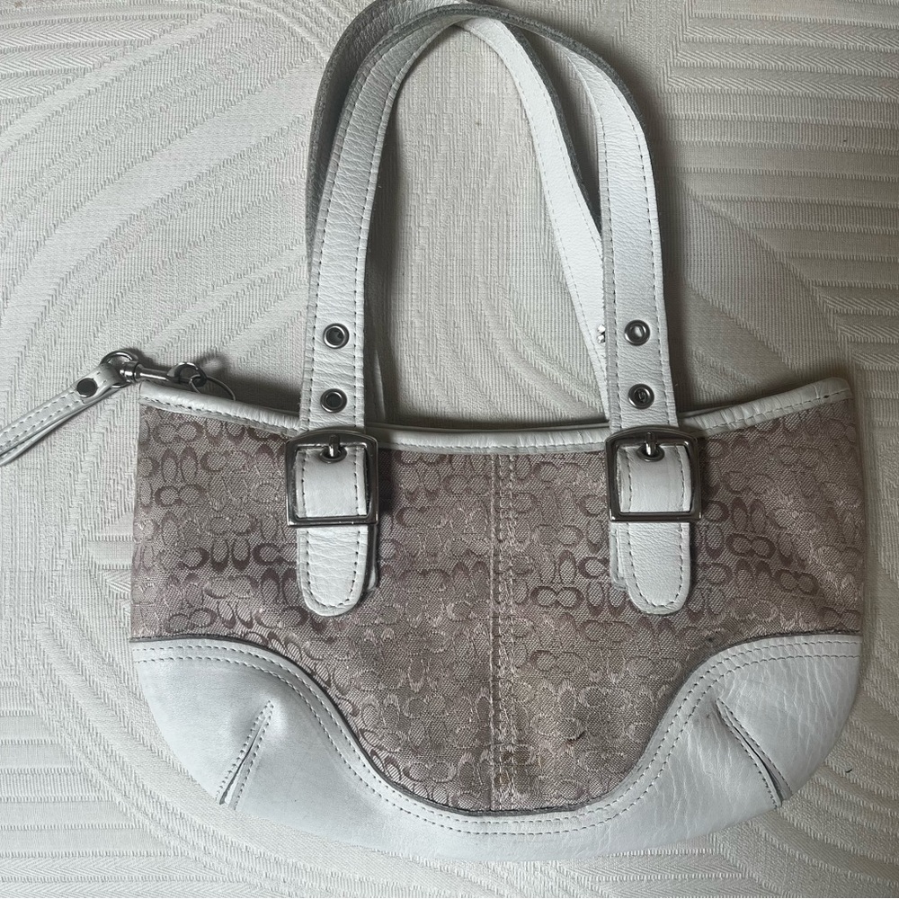 Small, white and tan coach bag.